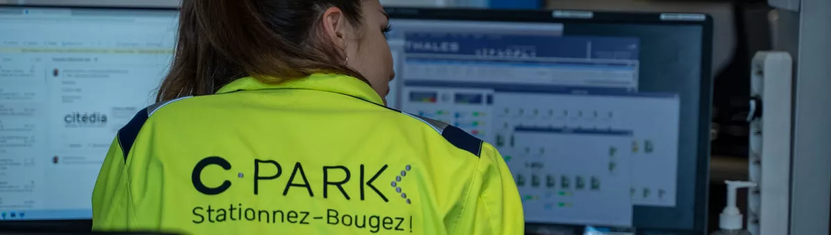 une collaboratrice de dos au bureau d'un parc de stationnement